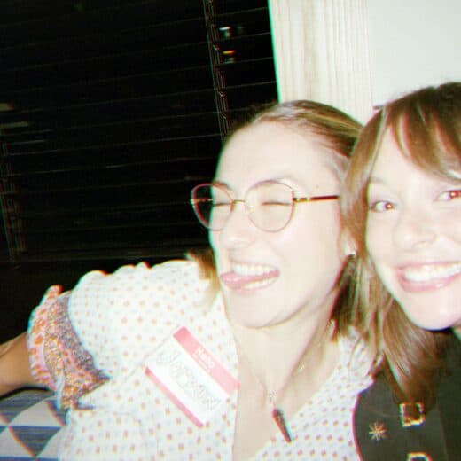 Two guests grinning cheek to cheek at dinner