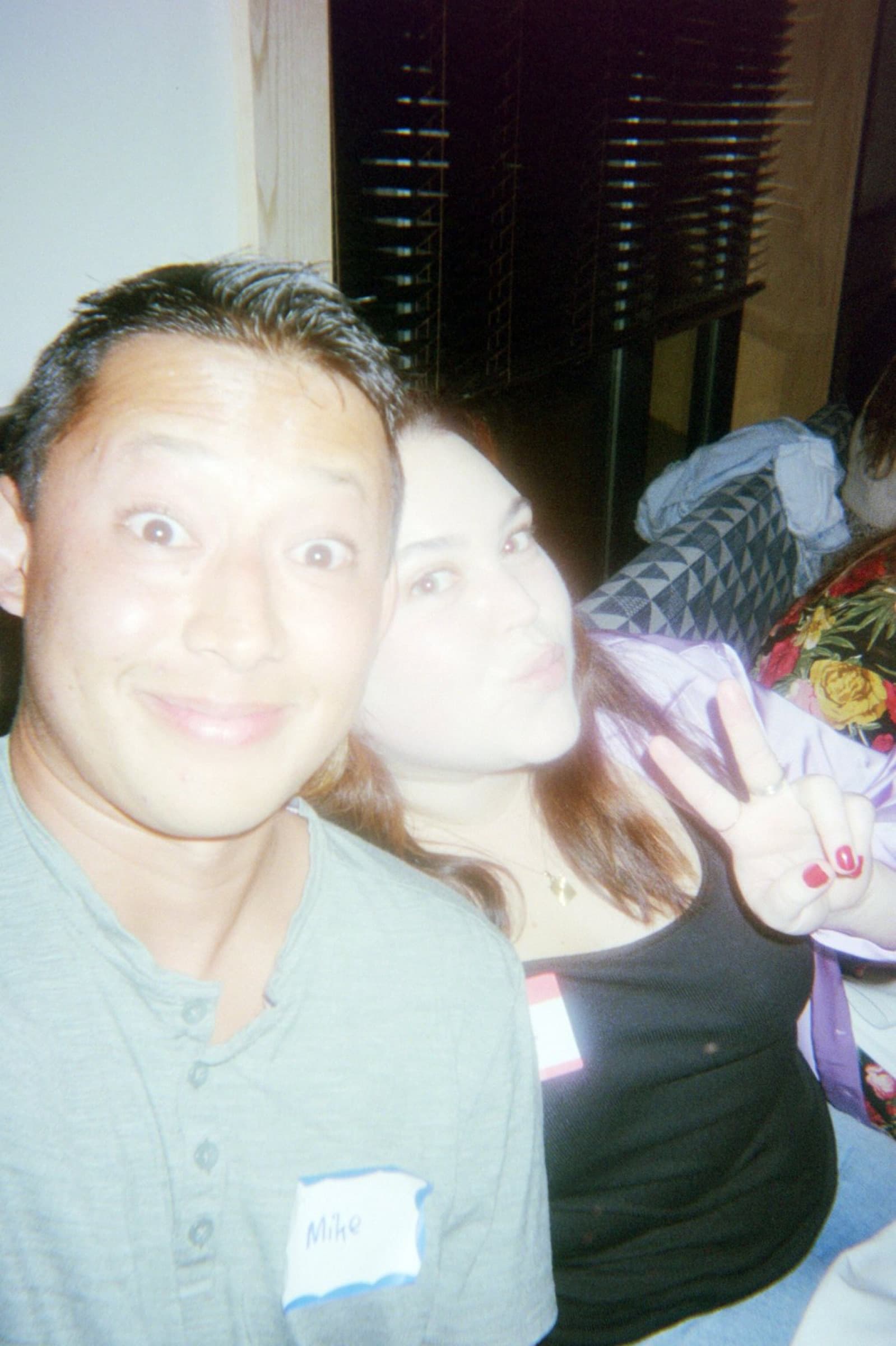Two guests posing for a selfie, one flashing a peace sign